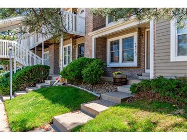 Charming townhome featuring a well-manicured lawn, brick facade, and inviting entrance stairs at 4676 S Dillon Ct # G, Aurora, CO 80015