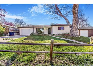 Charming white brick ranch with a well-manicured lawn, mature trees and a detached garage at 135 Garnet St, Broomfield, CO 80020