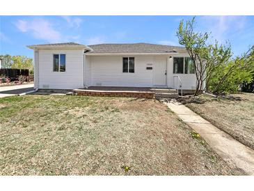 Charming one-story home with white siding, brick accents, and a well-manicured front yard at 9400 High St, Thornton, CO 80229