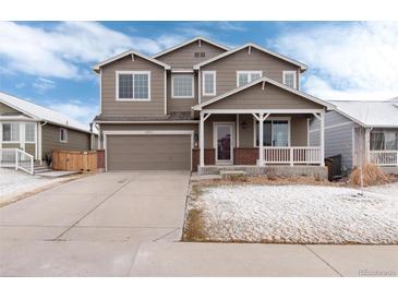 Inviting two-story home with a covered front porch, neutral paint, attached garage, and landscaped front yard at 12569 S Sopris Creek Dr, Parker, CO 80134