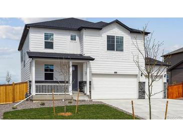 Charming two-story home with a manicured front yard and a two-car garage on a sunny day at 13802 Quartz St, Mead, CO 80504