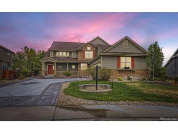 Charming two-story home with a well-manicured lawn, stone accents and a welcoming red front door at 22911 E Euclid Cir, Aurora, CO 80016