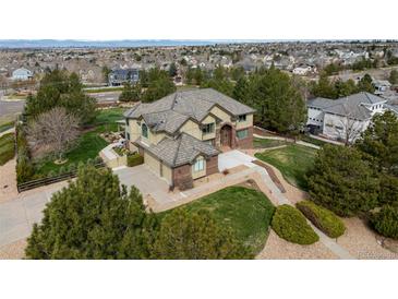 Expansive exterior elevation of home featuring a three car garage, pristine lawn, and mature trees at 6391 S Malaya St, Centennial, CO 80016