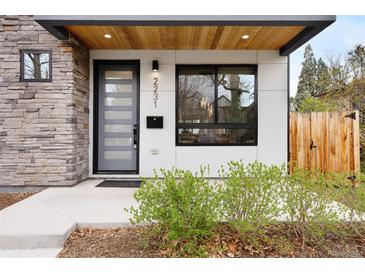 Contemporary home featuring a modern front door, stone accents, and natural wood ceiling at 2231 W 36Th Ave, Denver, CO 80211