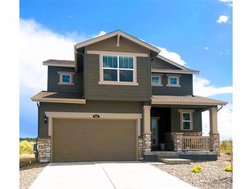 Inviting two-story home showcasing a neutral color palette, stone accents, a wide driveway, and a covered porch at 996 Kolz Pt, Elizabeth, CO 80107
