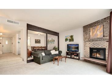 Cozy living room features a fireplace and access to a private patio at 3855 S Monaco St # 170, Denver, CO 80237