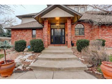 Brick home with a covered entryway and landscaped walkway at 1036 Lexington Ave, Westminster, CO 80023