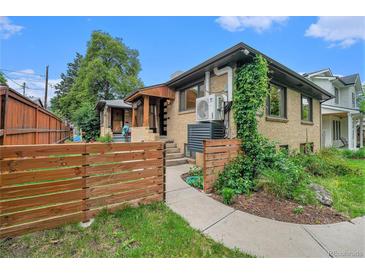 Charming brick home featuring a cozy front porch and well-maintained landscaping at 1111 Monroe St, Denver, CO 80206