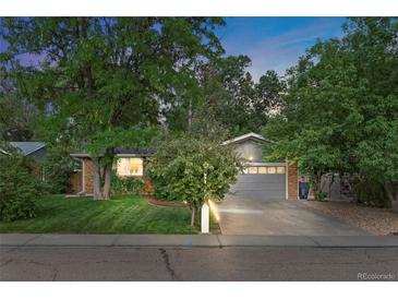 Charming single-Gathering home featuring a lush front yard, mature trees, and an attached two-car garage at 1746 Shavano St, Longmont, CO 80504