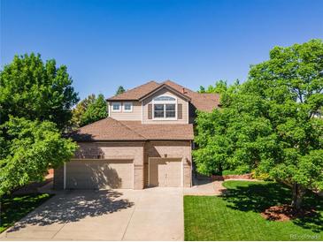 Charming two-story home with a three-car garage, lush landscaping, and a well-maintained front yard at 10565 Kalahari Ct, Lone Tree, CO 80124