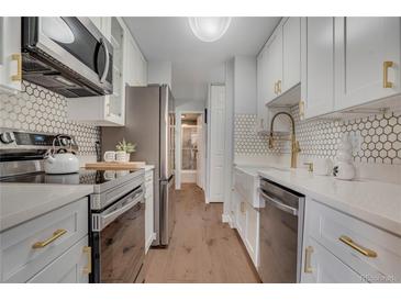Bright kitchen featuring stainless steel appliances, white cabinetry, and modern hardware at 4800 E Hale Pkwy # 712N, Denver, CO 80220