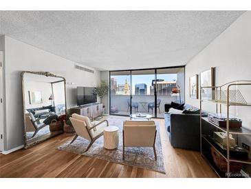 Bright living room with city view, hardwood floors, and stylish furniture at 1020 15Th St # 27E, Denver, CO 80202