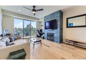 Bright living room featuring a fireplace, ceiling fan, and sliding doors to a balcony with lovely views at 9019 E Panorama Cir # D218, Englewood, CO 80112