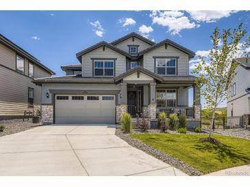 Charming two-story home showcasing a manicured lawn, neutral-toned exterior, and a welcoming front porch at 15210 W Eastman Ave, Morrison, CO 80465
