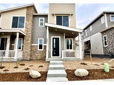 Modern two-story home featuring stone accents, a black front door, and well-manicured landscaping at 6632 N Nepal Ct, Aurora, CO 80019
