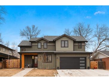 Charming two-story home showcasing neutral siding, a black garage door, and a cozy covered porch at 501 Lois Dr, Louisville, CO 80027