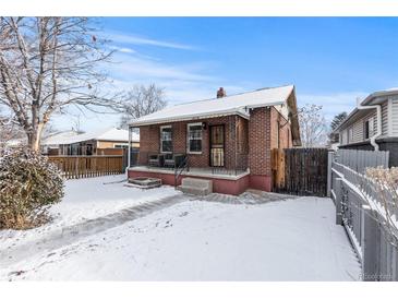 Charming brick home with a cozy front porch and snow-covered yard at 4518 Vallejo St, Denver, CO 80211