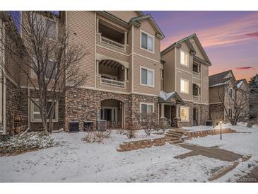 Inviting condo building with stone accents, balconies, and manicured landscaping, perfect for comfortable living at 8358 S Independence Cir # 105, Littleton, CO 80128