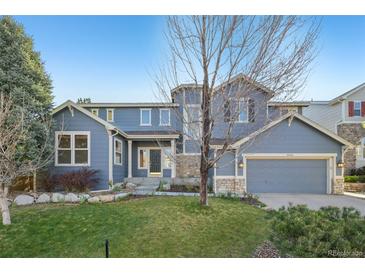 Charming two-story home featuring blue siding, a well-manicured lawn, and an attached two-car garage at 2660 Timberchase Trl, Highlands Ranch, CO 80126