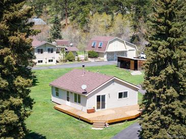 Charming exterior view of ranch style home with a spacious wooden deck and a well maintained lawn at 10039 S Turkey Creek Rd, Morrison, CO 80465