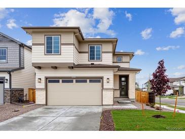Inviting two-story home featuring a spacious driveway and beautifully landscaped front yard at 9297 Truckee Ct, Commerce City, CO 80022