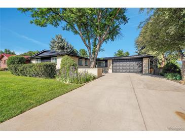 Charming brick home featuring a well-maintained front yard, mature trees, and a spacious driveway at 7018 Reed Ct, Arvada, CO 80003