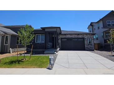 Beautiful modern home featuring stone accents, a two-car garage, and professionally landscaped front yard at 418 Grey Rock St, Brighton, CO 80601