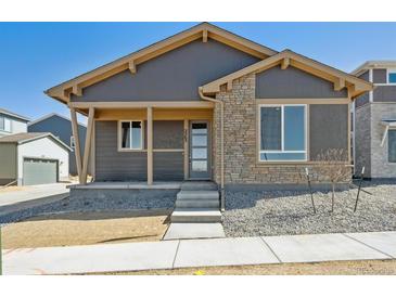 Charming single-story home featuring stone accents and a covered front porch at 2263 Serenidad St, Brighton, CO 80601