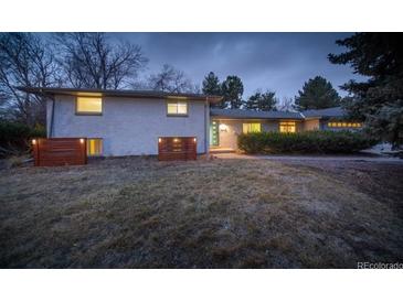 Charming one-story home with gray brick, manicured lawn, and mature trees, offering a serene setting at 2605 Crabapple Ct, Golden, CO 80401
