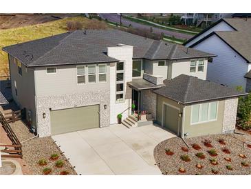 Stunning, modern home with a three-car garage, stone accents, and manicured landscaping for great curb appeal at 455 Rogers Way, Castle Rock, CO 80104