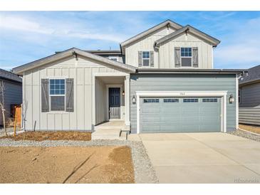 Two-story home with gray siding, shutters, and a two-car garage at 1563 Orchard St, Brighton, CO 80601