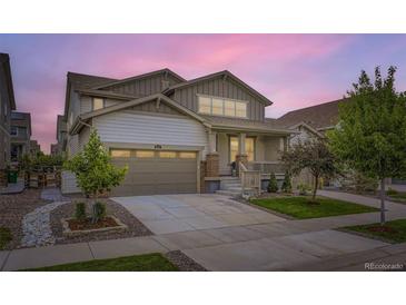 Charming home featuring a two-car garage, covered front porch, and well-maintained landscaping at 1063 Sandstone Cir, Erie, CO 80516