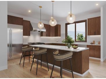 Modern kitchen with stainless steel appliances, center island, and three pendant lights, and mountain view from the window at 526 N Fuller Placer Rd, Breckenridge, CO 80424