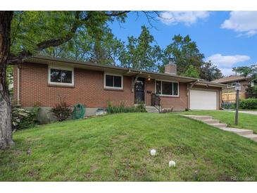 Charming brick home featuring a well-manicured lawn and an attached garage under a bright blue sky at 8299 E Kenyon Ave, Denver, CO 80237
