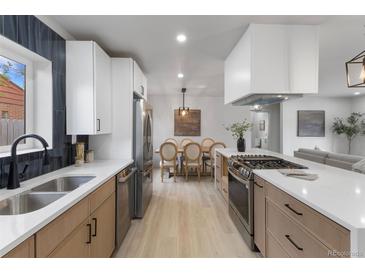 Bright kitchen featuring stainless steel appliances, quartz countertops, and dining area at 6839 E 21St Ave, Denver, CO 80207
