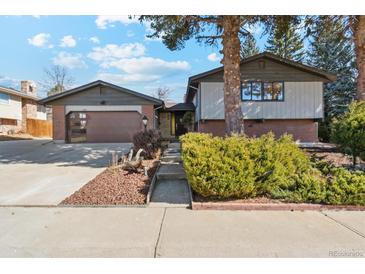 Charming two-story home with brick accents, attached garage, and a well-maintained front yard landscape at 10121 W 70Th Dr, Arvada, CO 80004