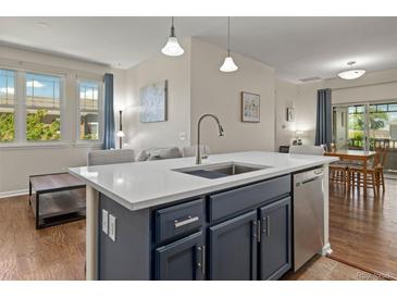 Bright kitchen featuring an island with a sink, stainless steel appliances, and an open floorplan at 837 E 98Th Ave # 405, Thornton, CO 80229