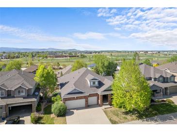 Charming two-story brick home with a well-maintained lawn and mountain views in a peaceful, green neighborhood at 1513 Cannon Mountain Dr, Longmont, CO 80503