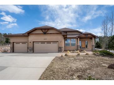 Stucco house with three-car garage and stone accents at 20217 Kenneth Lainer Dr, Monument, CO 80132