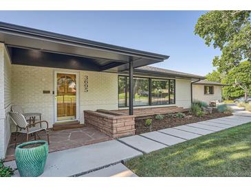 Inviting front exterior with a covered porch, modern landscaping, and a charming entrance at 3695 E Dartmouth Ave, Denver, CO 80210