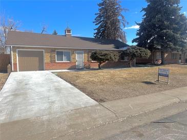 Charming single-story home with brick accents, attached garage, and well-maintained front yard at 1120 Tucson St, Aurora, CO 80011