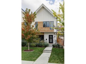 Modern two-story home with wood and white exterior, landscaping, and walkway at 3422 S Grant St, Englewood, CO 80113