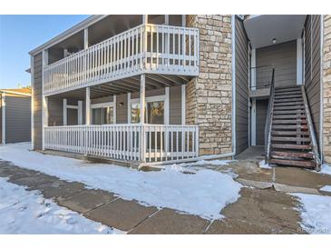 Inviting condo complex showcasing stone accents, snow dusted walkway and private balconies for outdoor enjoyment at 18105 E Ohio Ave # 102, Aurora, CO 80017