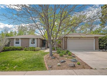 Charming brick home featuring a manicured lawn and beautiful landscaping at 8150 W Calhoun Dr, Littleton, CO 80123