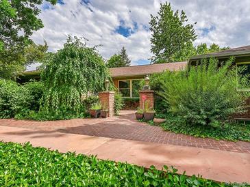 Charming home featuring brick walkway, manicured landscaping, and classic architectural details at 6550 E 6Th Avenue Pkwy, Denver, CO 80220