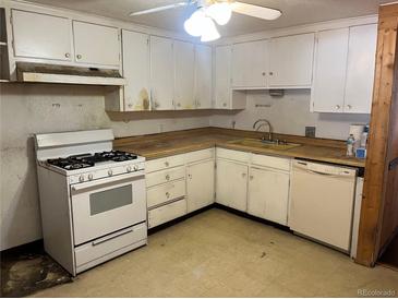 White kitchen features gas range, dishwasher, and ample cabinets at 6500 W 14Th Ave, Lakewood, CO 80214