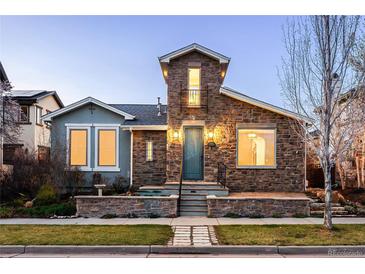 Charming stone-front home featuring a tower with a small balcony and a beautifully landscaped yard at 9715 E 33Rd Ave, Denver, CO 80238