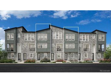 Beautiful townhome with stone and modern gray siding, paired windows and individual front balconies at 20588 E 63Rd Ave, Aurora, CO 80019