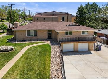 Charming ranch-style home with a brick facade, manicured lawn, and convenient two-car garage at 2704 S Ames Way, Denver, CO 80227