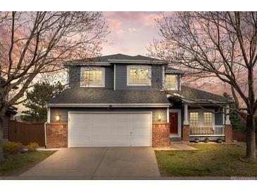 Charming two-story home featuring a brick facade, a two-car garage, and a cozy front porch at 4235 Lark Sparrow St, Highlands Ranch, CO 80126